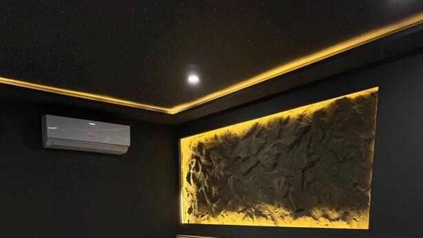 Een moderne slaapkamer met een bed, nachtkastjes en een uniek kunstwerk aan de muur.