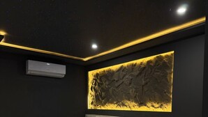 Een moderne slaapkamer met een bed, nachtkastjes en een wandairconditioner.