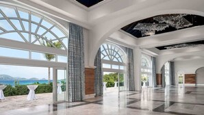 Un intérieur spacieux avec de grandes fenêtres, un plafond haut et une vue sur la mer.