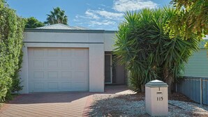A residential garage with a white door, a small tree, and a mailbox with the number 115. - Mildura City Centre Escape 2 (Mildura)