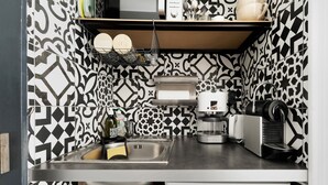 A kitchen with a sink, coffee maker, and a microwave.