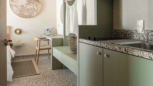 A modern kitchen with a granite countertop, a built-in sink, and a hanging rack. - FOS Luxury Suites (Nikiti)