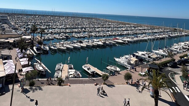 A marina with numerous boats docked, a clear blue sky, and a calm sea. - Sea view apartment (Palavas-les-Flots)