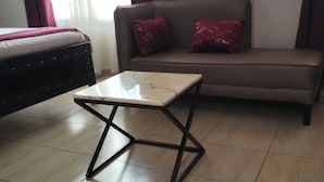 Un salon avec un canapé, une petite table et un lit.