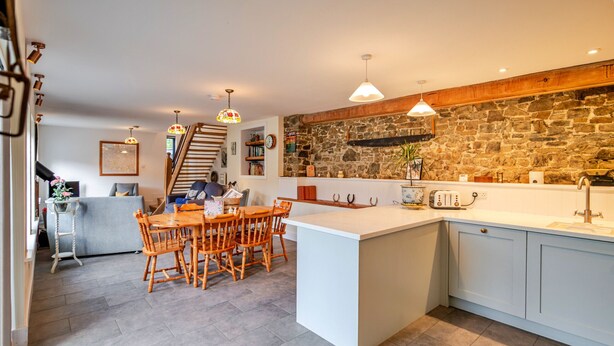 Une cuisine moderne avec un îlot central, des chaises en bois et une table à manger.