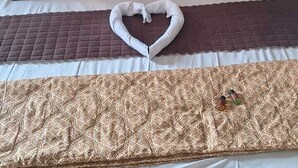 A bed with a headboard, pillows, and a blanket. - Hotel Awadh Grand (Kanpur)