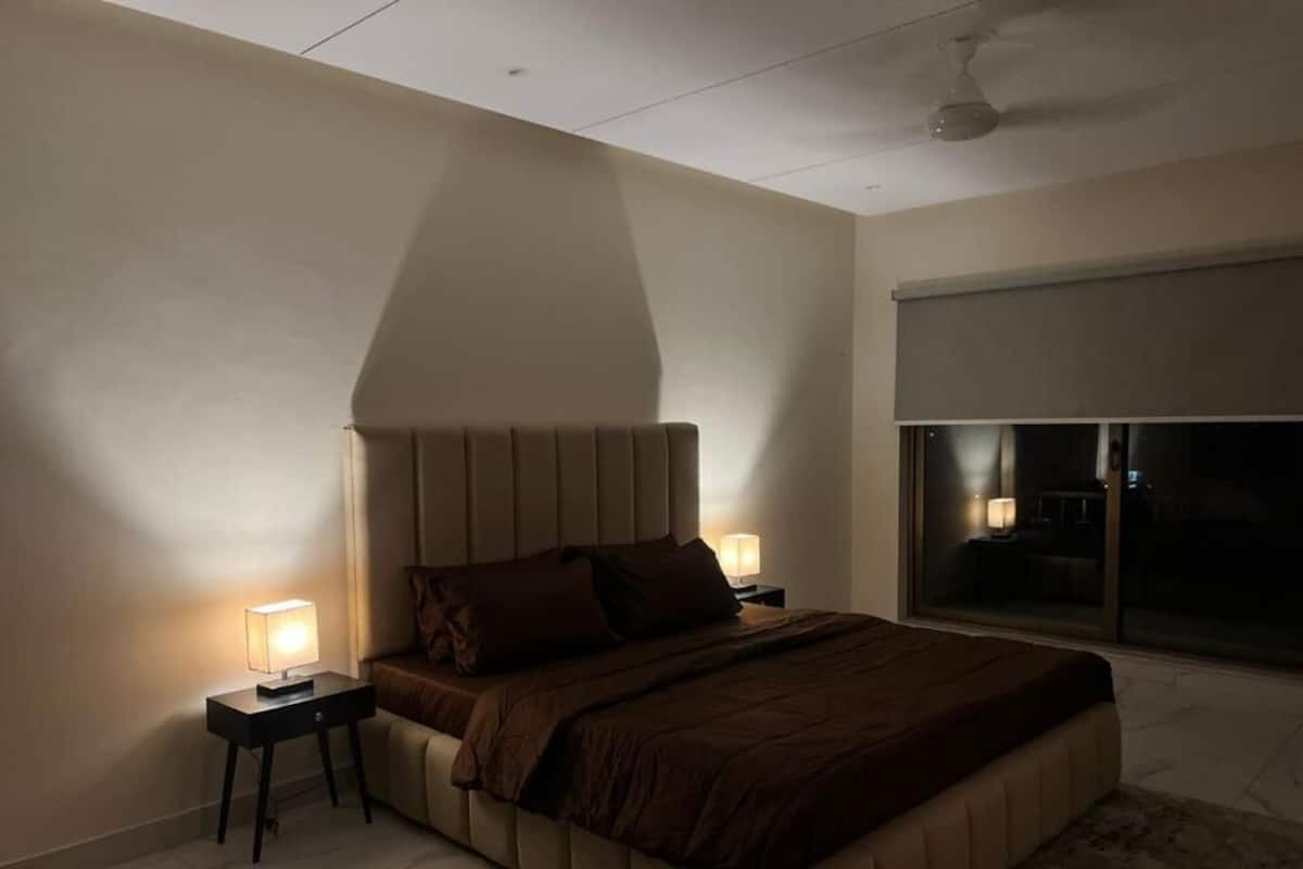 Ein Schlafzimmer mit einem Bett, Nachttischen und einem Deckenventilator.