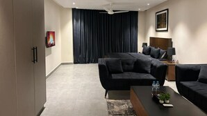 Uma sala de estar moderna com um sofá seccional, uma mesa de centro e um ventilador de teto.