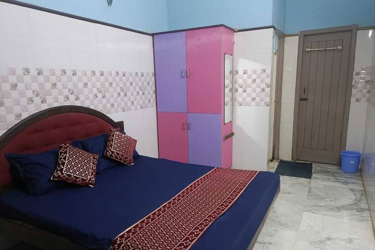 A bedroom with a bed, a wardrobe, and a door.