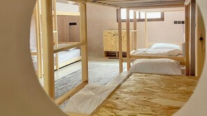 A circular view of a room with two wooden bunk beds, a wooden headboard, and a window. - tayri surf house (Aourir)