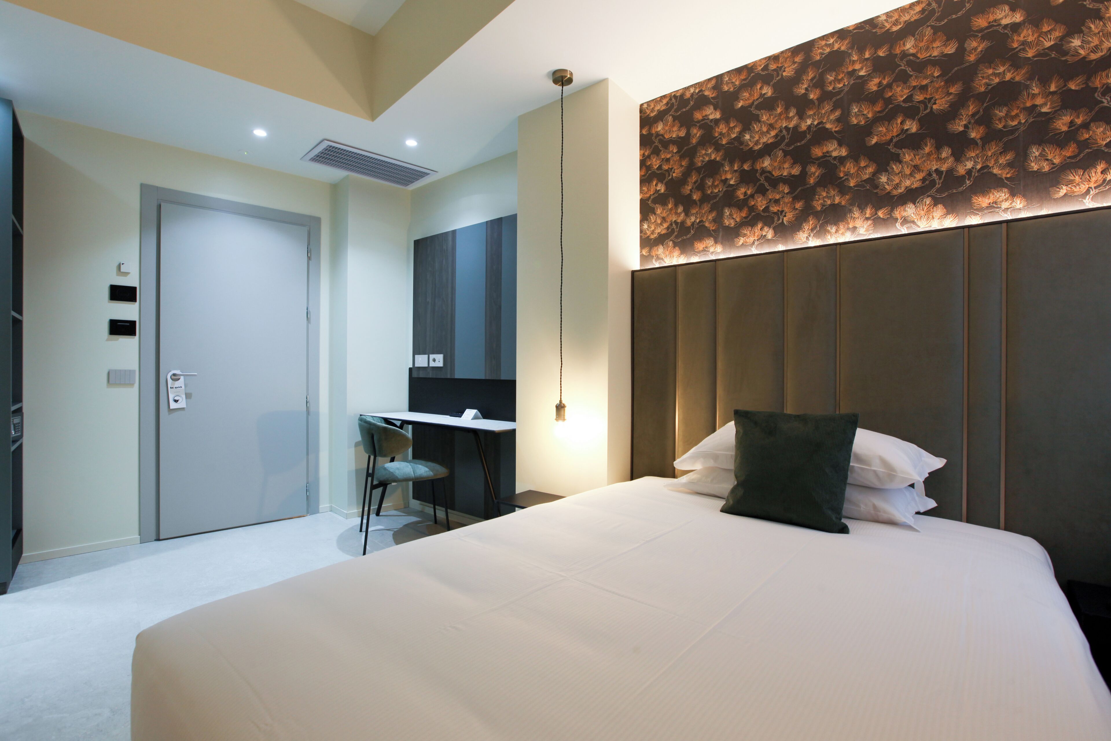Une chambre d’hôtel avec un grand lit, un bureau et une chaise.
