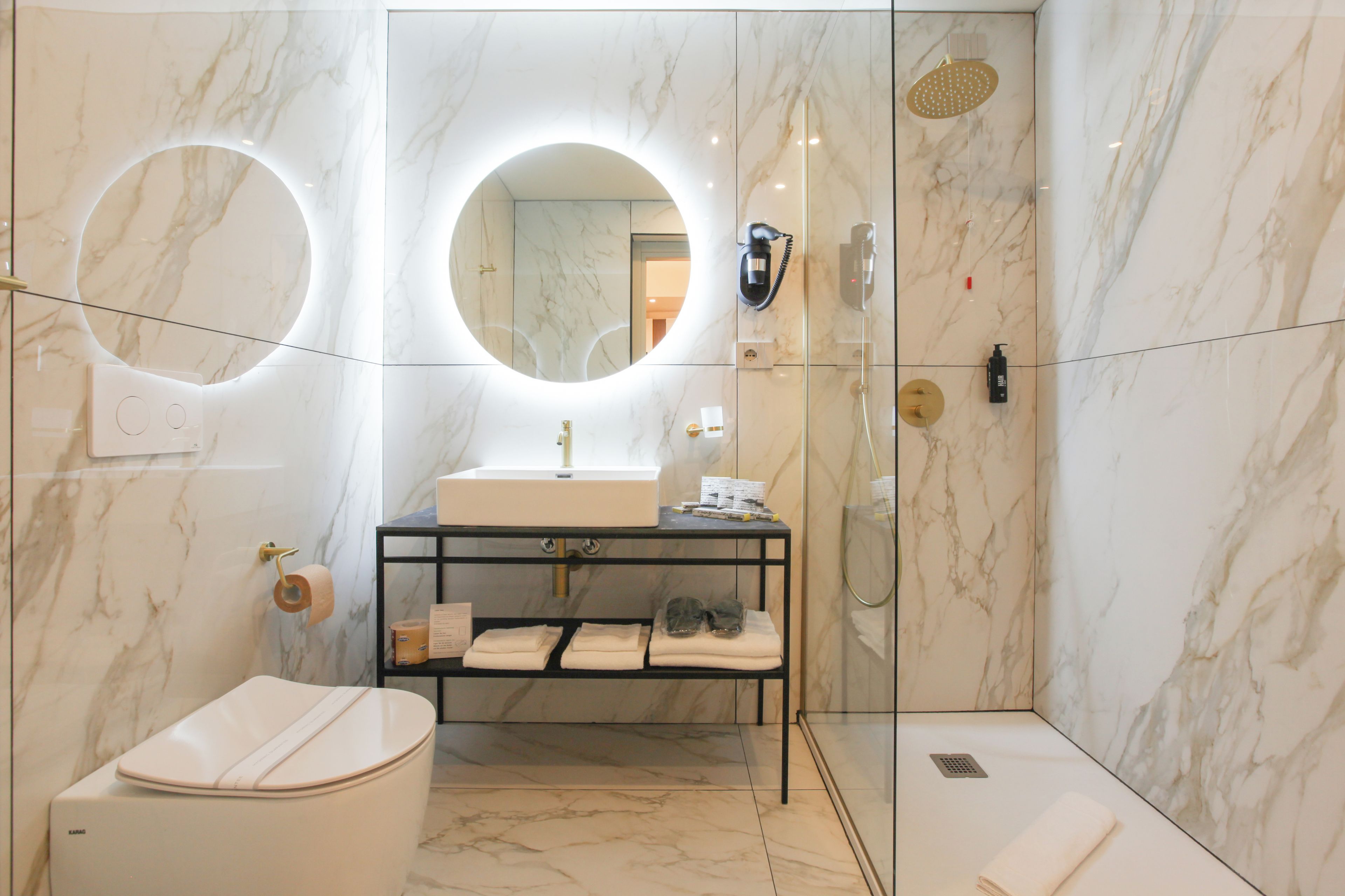Un baño moderno con inodoro, lavamanos y ducha.