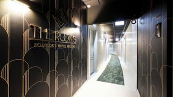 Un pasillo con un cartel que dice "THE ROOMS Boutique Hotel Milano".