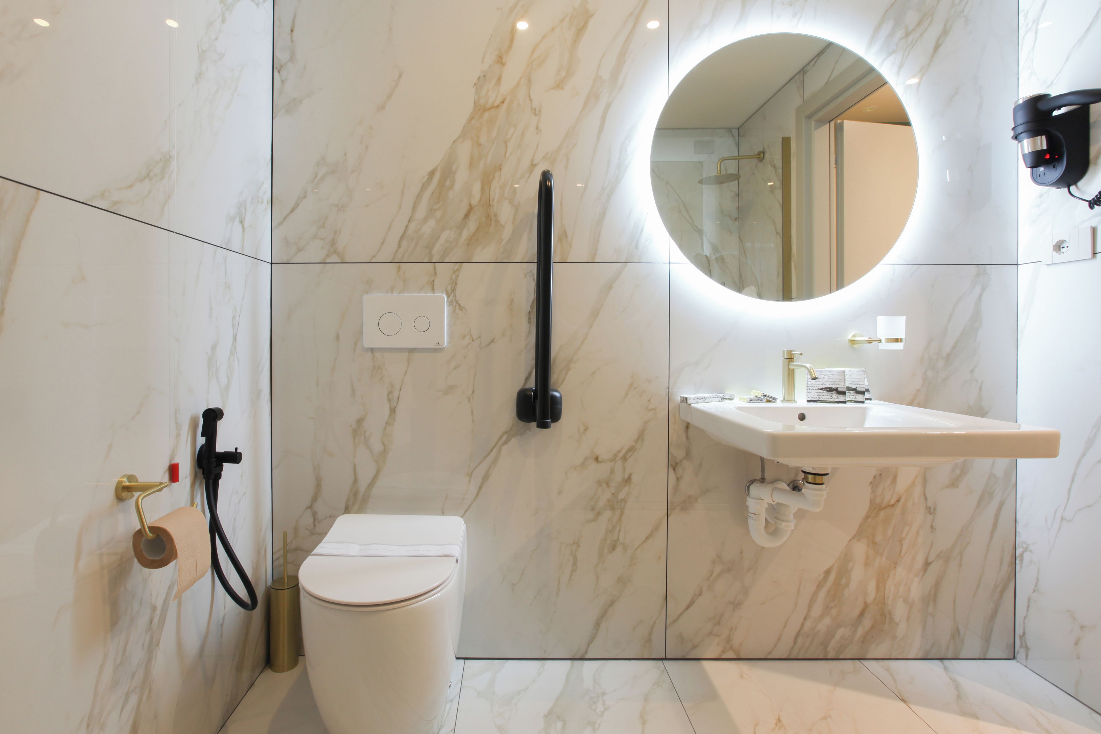 Une salle de bain moderne équipée de toilettes, d’un lavabo et d’un espace douche.
