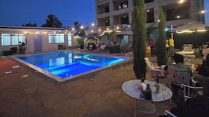 Un espace extérieur avec une piscine, un bâtiment se dressant en arrière-plan.