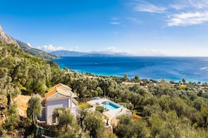 A coastal villa with a swimming pool, surrounded by dense greenery and overlooking the sea. - Villa Chronis in Mparmpati (Corfu)