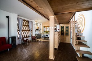 A spacious living area with a wooden floor, a red sofa, a fireplace, and a dining area with a chandelier. - LIG020-021 House with pool and garden. (Colombiera-Molicciara)