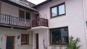 A two-story building with a balcony, a door, and a window. - Old farm f. Teams and families in the wine village with excellent connections (Albig)