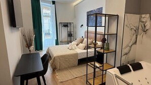 Una habitación de hotel moderna con cama, escritorio, silla, armario y baño.