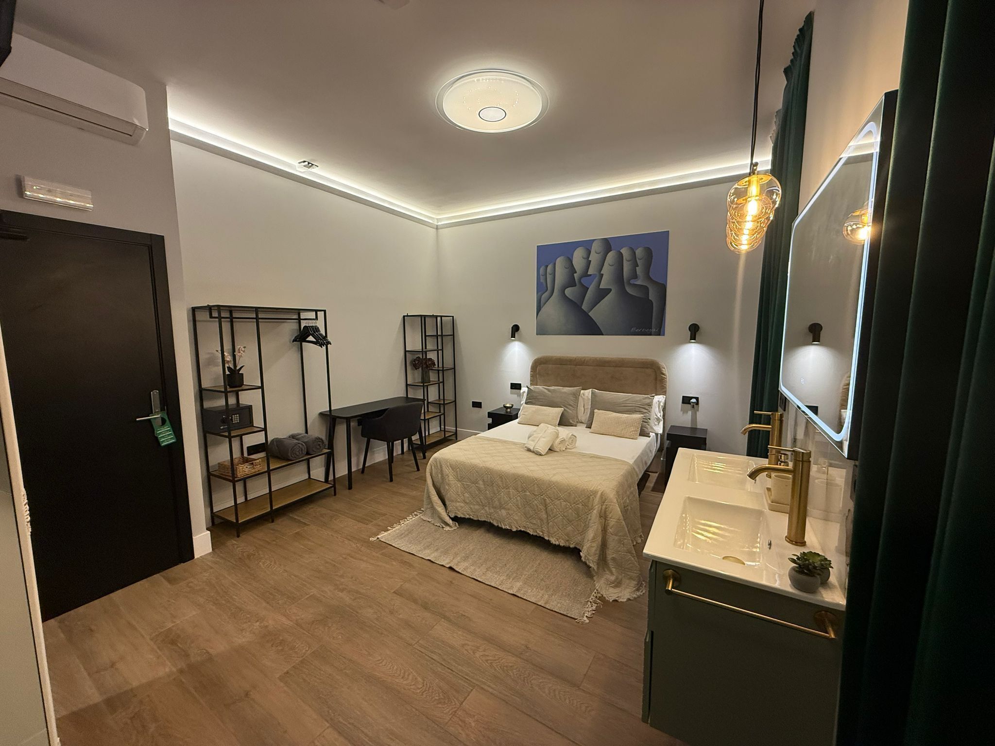 A modern bedroom with a bed, bedside tables, a desk, shelves, and a large mirror.