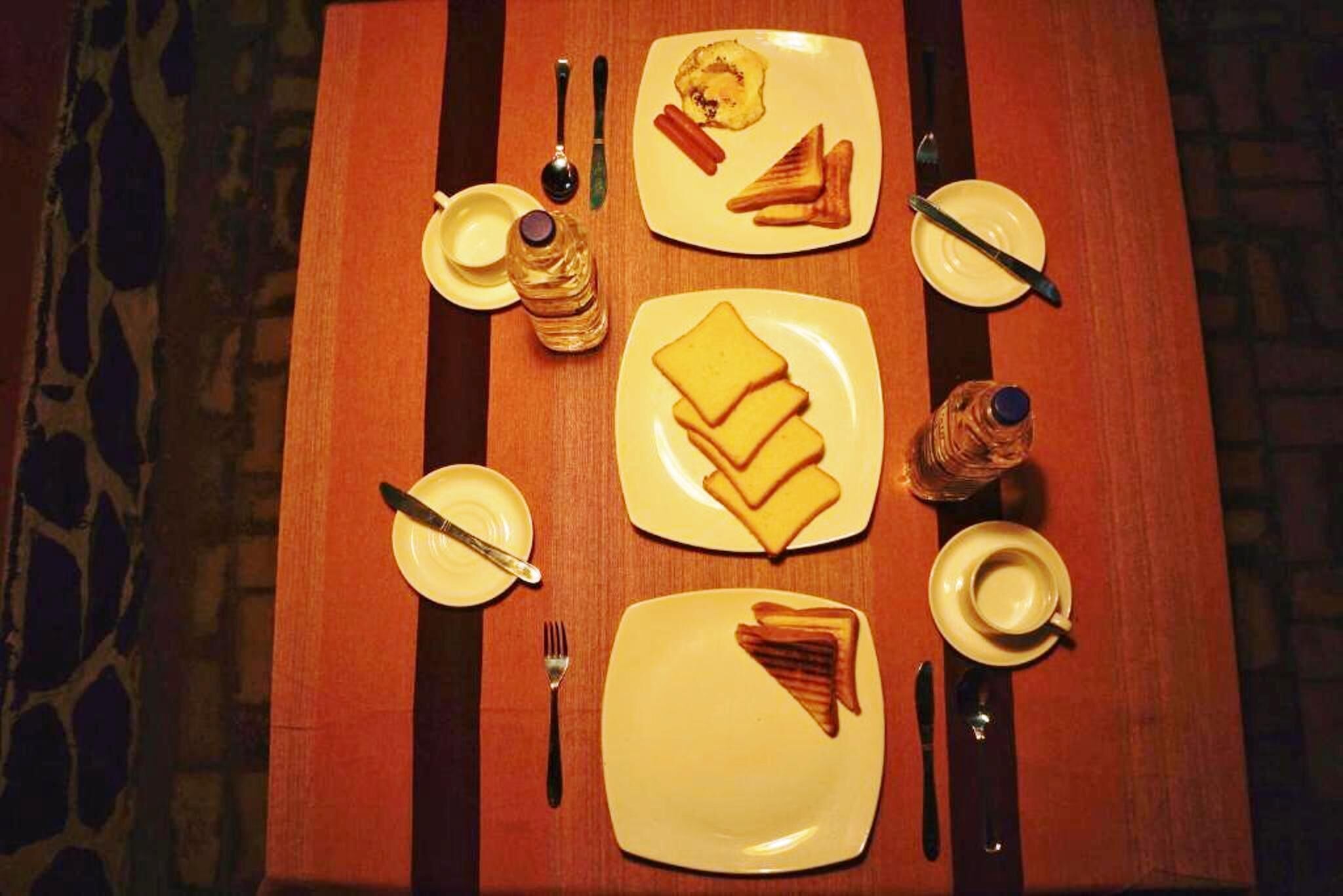 A table set with plates of toast, a bottle of water, and a cup of coffee.