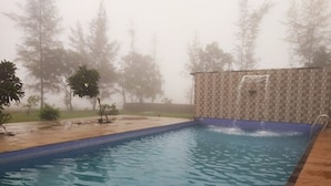 Una piscina con pared de azulejos y escalera.