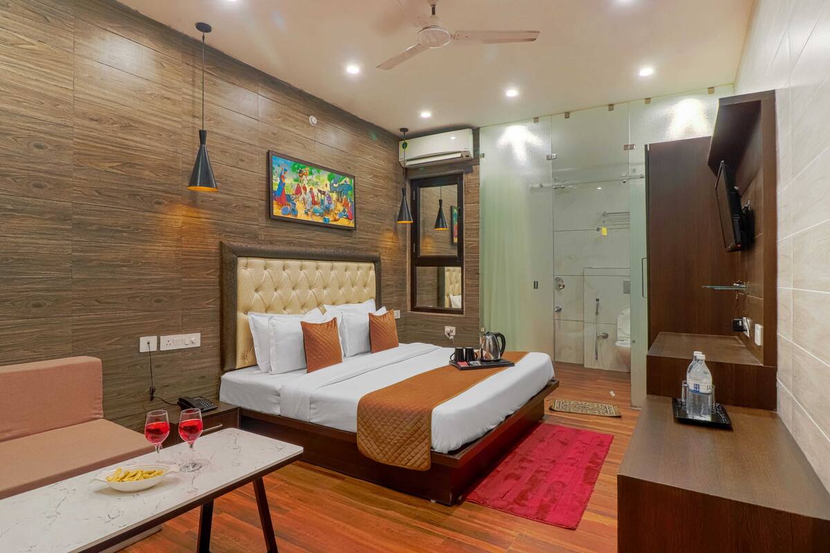 Una habitación de hotel moderna con una pared de madera, una cama grande, una mesita de noche y un tapete rojo, además de un área de ducha.