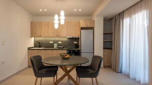 Una cucina moderna con mobili in legno, un tavolo da pranzo rotondo con due sedie e un forno a incasso.