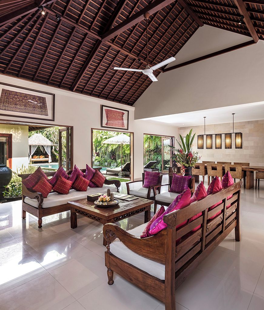 A spacious indoor area with wooden furniture, a ceiling fan, and a view of the outdoors.