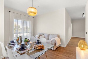 A modern living space with a dining area, a sofa, and a hanging light fixture. - B&B Apartments. Modern and Luxurious Apartment Less Than 100 Meters from the Beach (La Cala de Mijas)