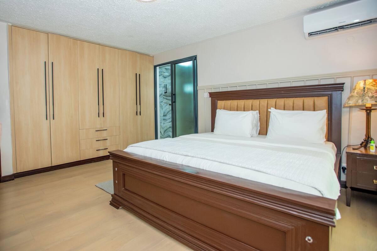 Ein Schlafzimmer mit einem hölzernen Bett, einem Schrank und einem Nachttisch mit einer Lampe.