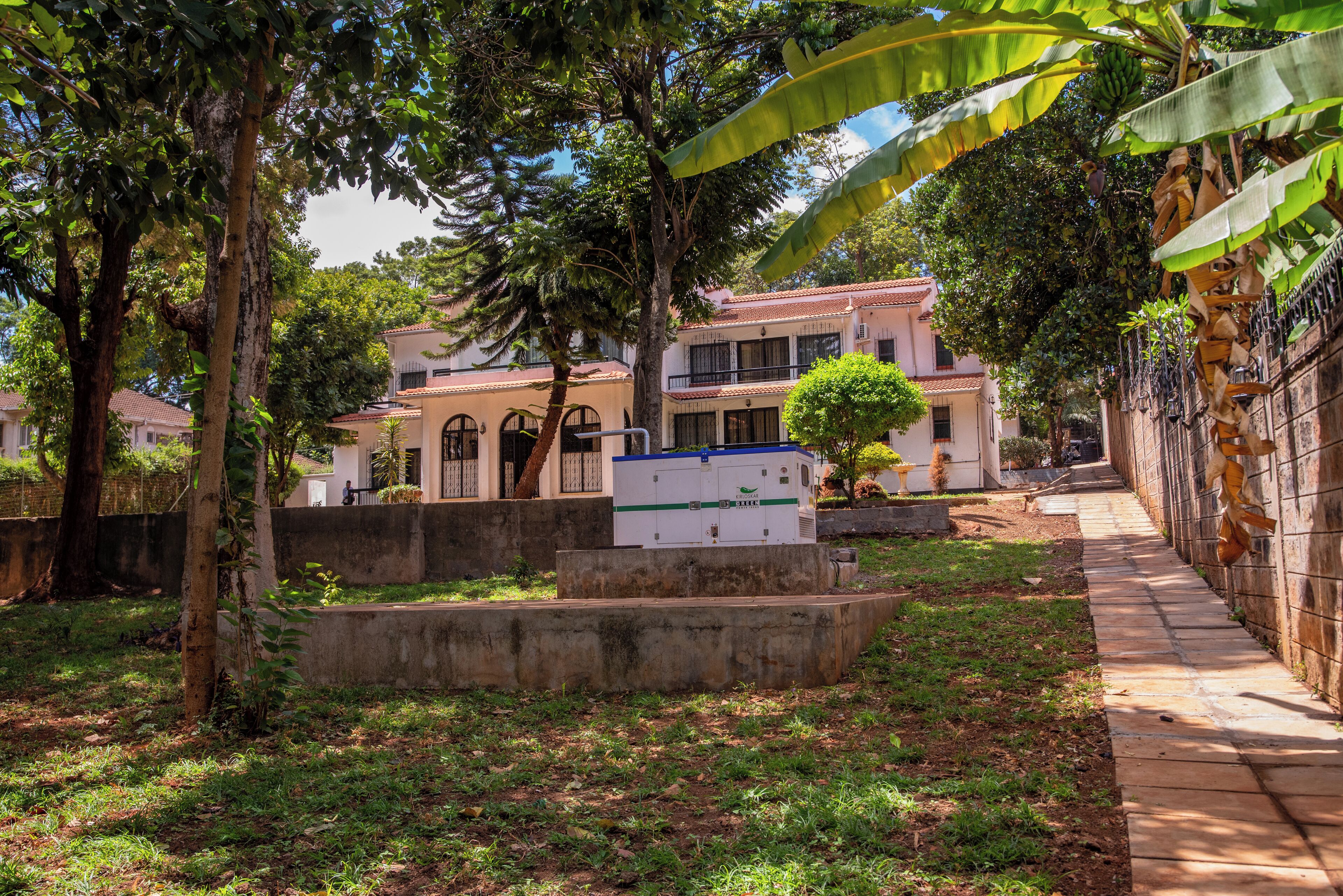 A courtyard with a building, trees, and a pathway.