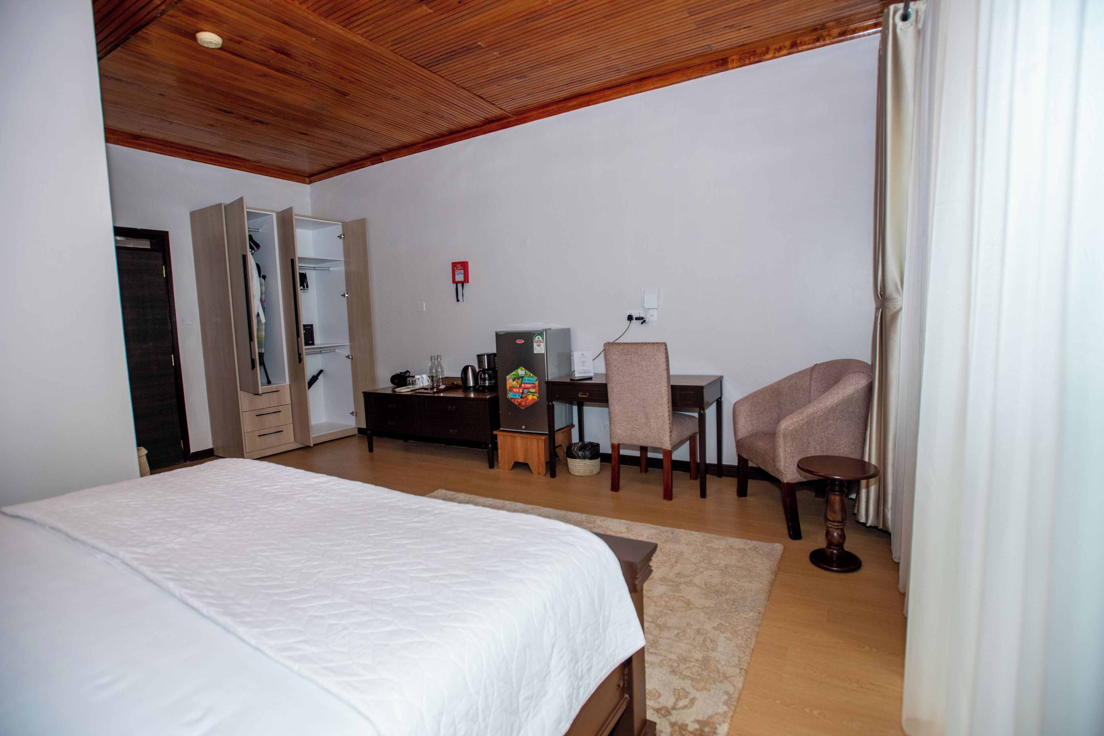 Ein Schlafzimmer mit einem Bett, einem Schreibtisch, einem Stuhl und einem kleinen Tisch.
