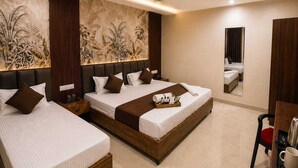 A hotel room with two beds, a large mirror, and a tray with toiletries. - Laxmi Vilas (Varanasi)