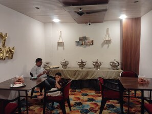 A conference room with a long table, chairs, and a ceiling fan. - Laxmi Vilas (Varanasi)