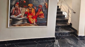 A staircase with a marble floor and a large painting of a traditional scene on the wall. - Laxmi Vilas (Varanasi)