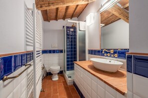 Une salle de bain avec une baignoire blanche, une douche et des toilettes.