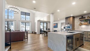 Una cocina amplia con una isla grande, piso de madera y muebles de cocina modernos.
