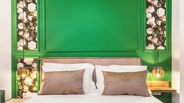 A bed with two pillows, a green wall, and a floral wallpaper design. - Standard Mountain View Retreat – Cozy Apartment with Stunning Views for Up to 4 (Axos, Mylopotamos)