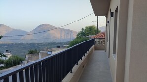 A balcony with a view of mountains and a red-roofed building in the distance. - Standard Mountain View Retreat – Cozy Apartment with Stunning Views for Up to 4 (Axos, Mylopotamos)