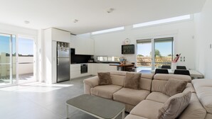 A modern kitchen with a refrigerator, oven, and dining area. - Villa Ginevra: Exclusive Luxury and Wellbeing Near Otranto (Otranto)