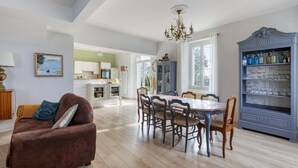 Un espacio habitable amplio con una mesa de comedor, sofá y un aparador decorativo.
