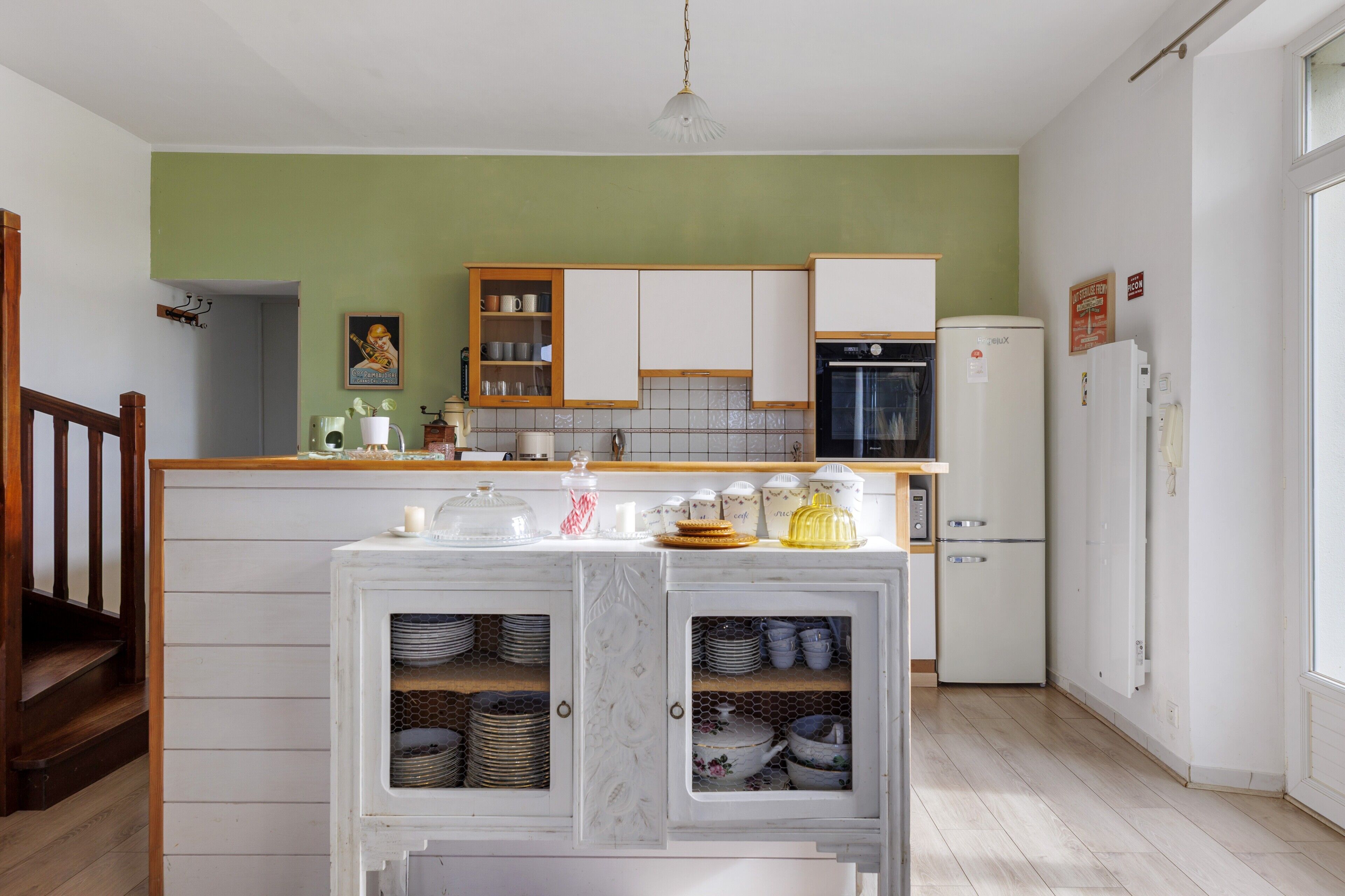 Een keuken met witte kastjes, een houten aanrechtblad en een ingebouwde kookplaat.
