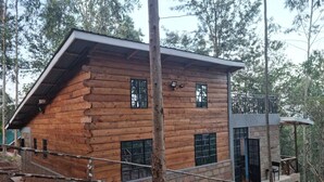 Una baita di legno con tetto spiovente, diverse finestre e un balcone.