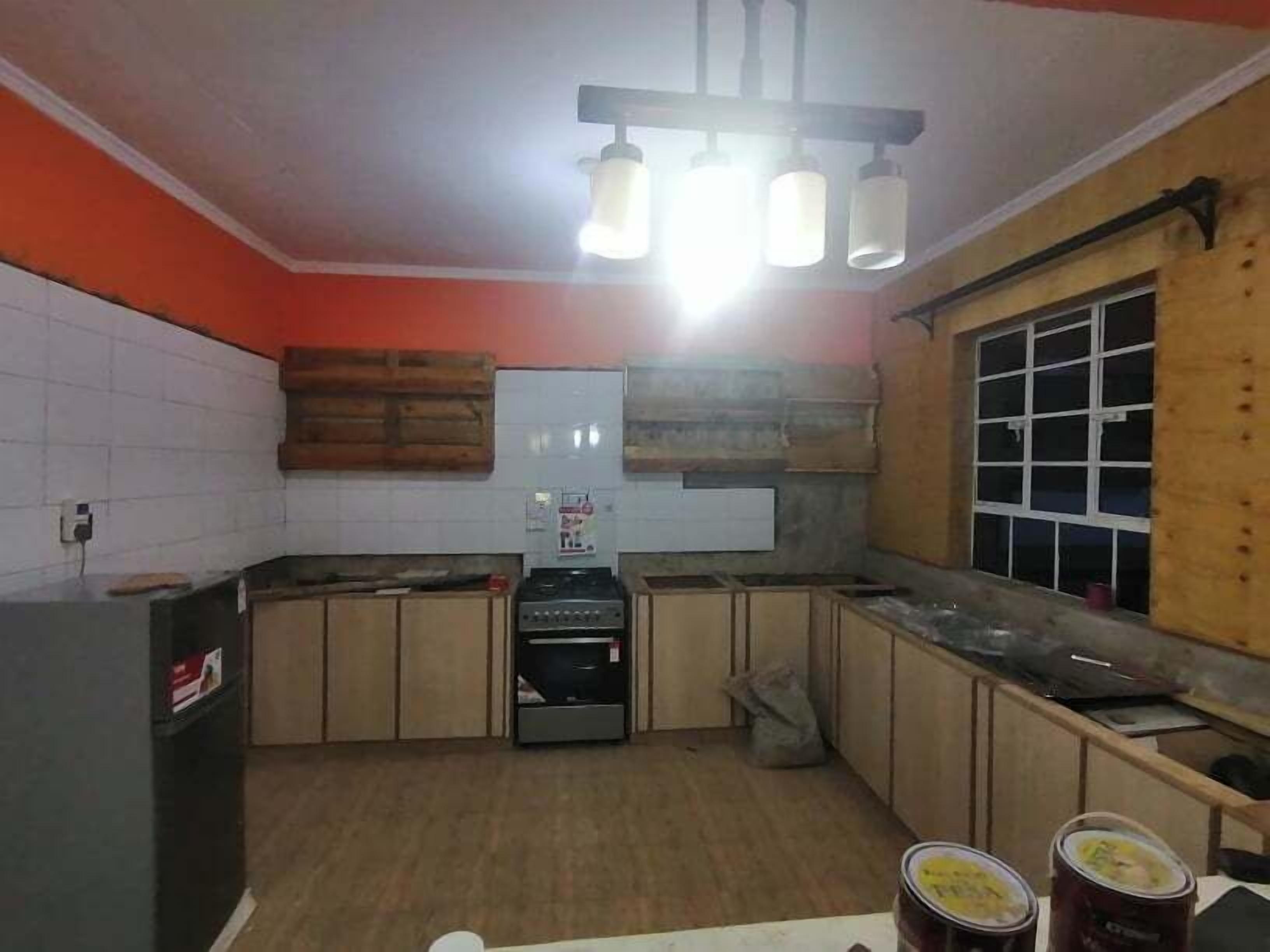 A kitchen with wooden cabinets, a built-in oven, and a window.