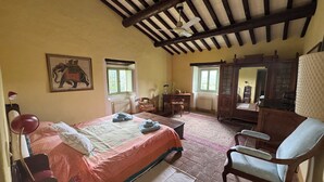 A bedroom with a bed, a chair, a desk, a radiator, and a window. - Country house with pool in Anghiari Arezzo (Anghiari)
