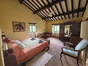 A bedroom with a bed, a chair, a desk, a radiator, and a window. - Country house with pool in Anghiari Arezzo (Anghiari)