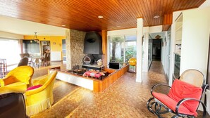 A spacious living area with a stone fireplace, wooden ceiling, and yellow chairs. - House with panoramic view of the Etel ria (Belz)