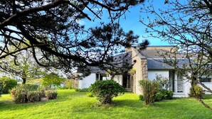 A house with a stone facade, surrounded by a well-maintained lawn and various shrubs. - House with panoramic view of the Etel ria (Belz)