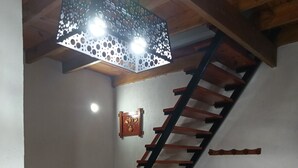 A staircase with wooden steps and black railings, a dining table with chairs, a fan, and a decorative wall piece. - House for rent in mar del plata, per day, per week or per fortnight (Mar del Plata)